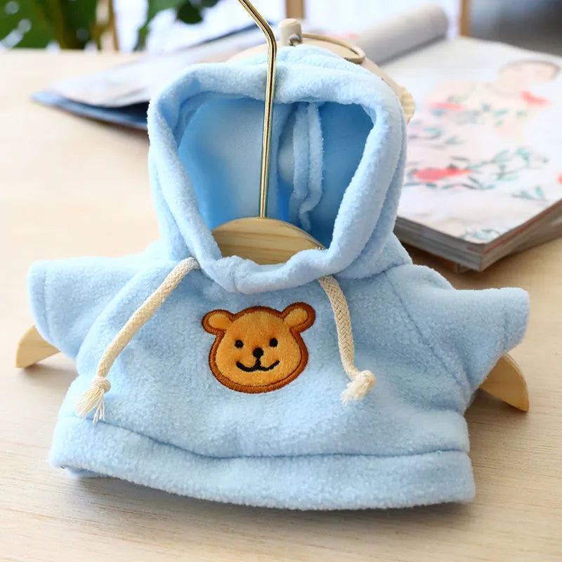 A small dog wearing a blue cloth hoodie sweater from the range of six available colours.