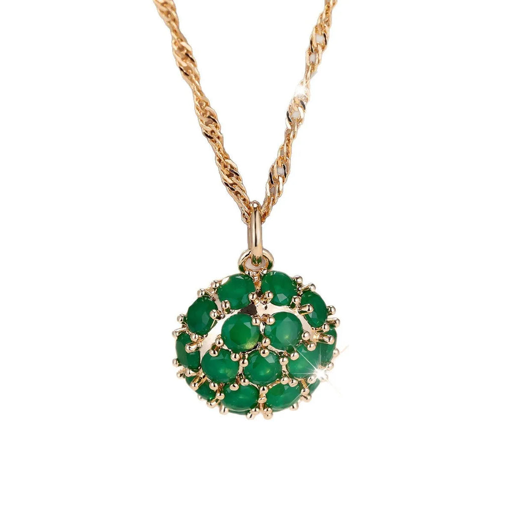Champagne gold geometric pendant necklace with a round emerald stone and diamond accents on an adjustable chain.