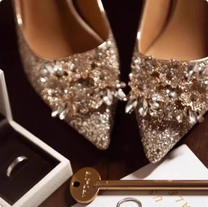 Champagne pointed-toe women's bridal shoes with floral rhinestone detail on a white background