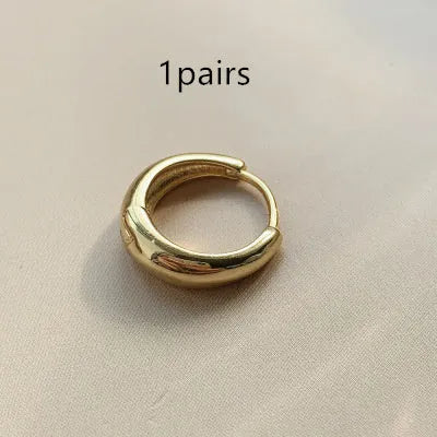 Women's minimalist copper water drop earrings in gold or silver, shown in large, medium, and small sizes.