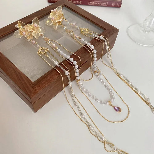 Gold grip hairpin for women with pearl, diamond, flower decorations and a long tassel.