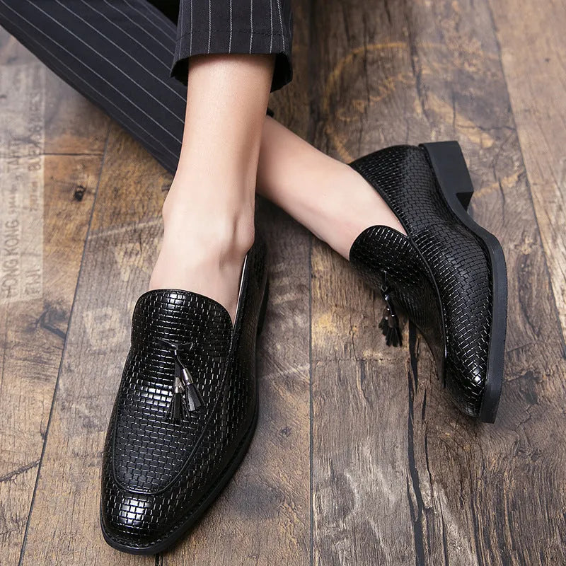 Men's black pointed toe slip on shoes with a gold tassel detail on the upper.