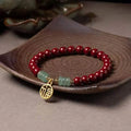 Gold cinnabar bracelet with wave design and copper beads in traditional Chinese style