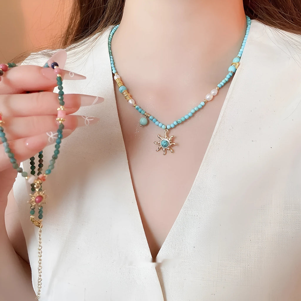 Sun necklace with a stone geometric pendant and freshwater pearls on a clavicle chain.