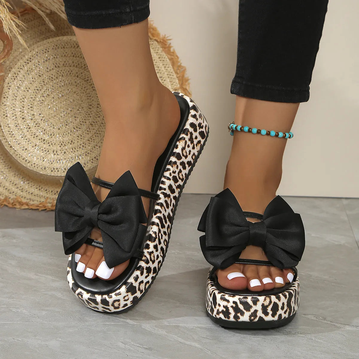 Black leopard print scaffold-shaped beach slippers with thick sole and round toe on white background