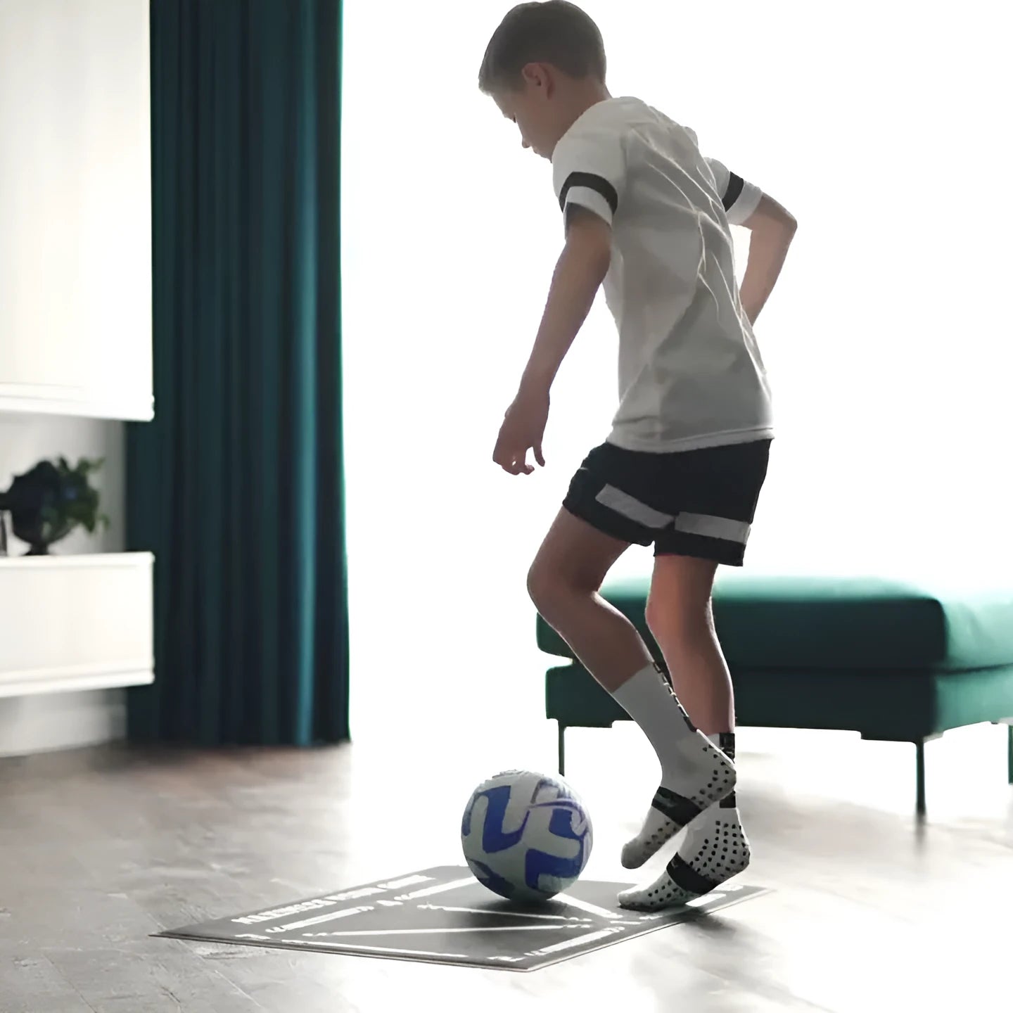 Black rectangular football training mat on a flat surface, dimensions 60cm by 90cm.