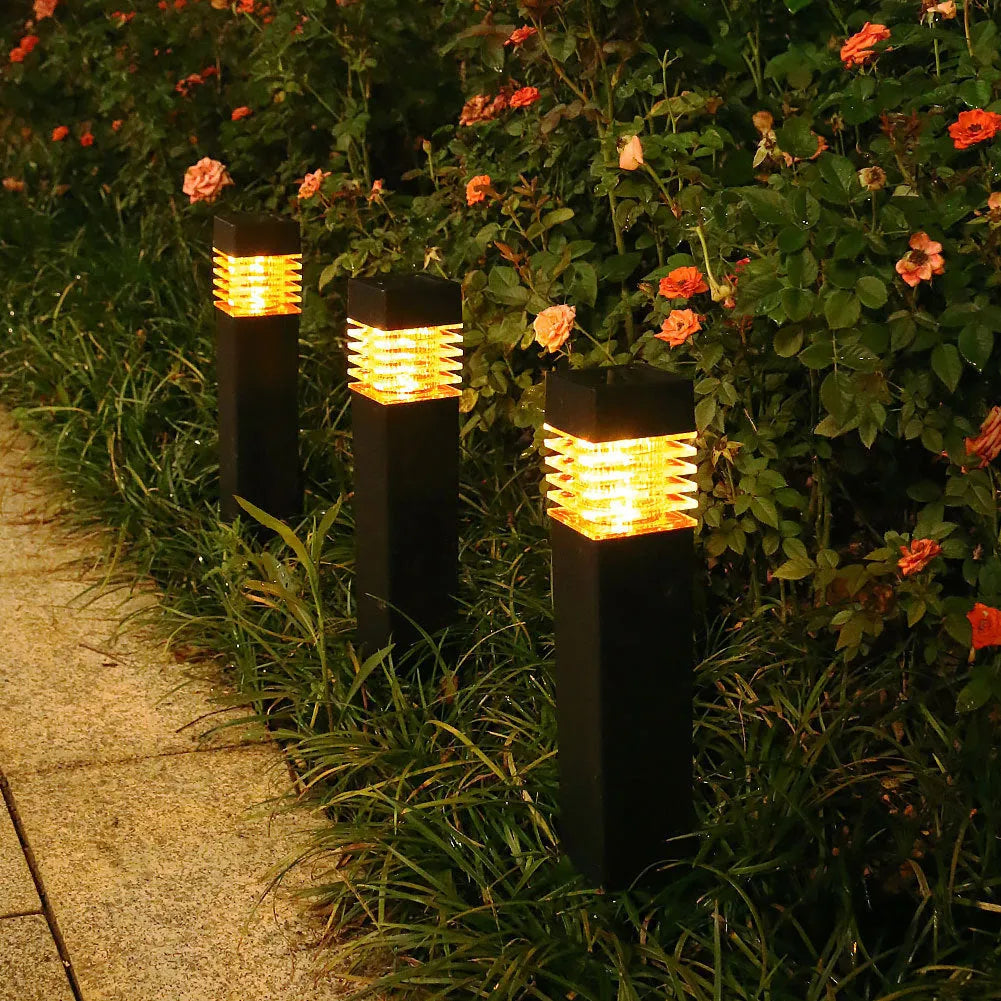 White cuboid solar-powered ground lamp for garden pathways with a solar panel on top.