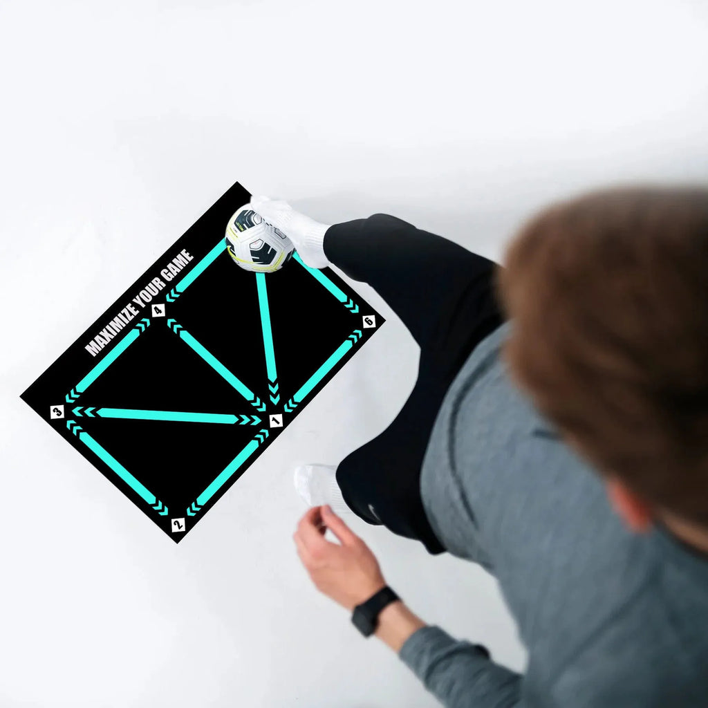 Black rectangular football training mat on a flat surface, dimensions 60cm by 90cm.