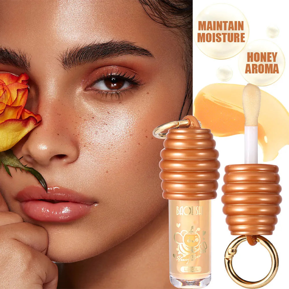 Honey coloured lip gloss on a silver keychain ring against a plain background.