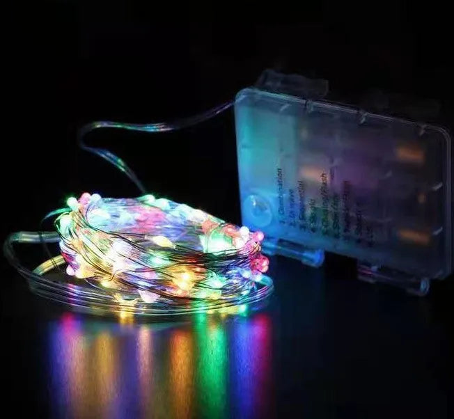 Copper wire LED string lights shaped around a bottle, showing multiple small coloured bulbs.