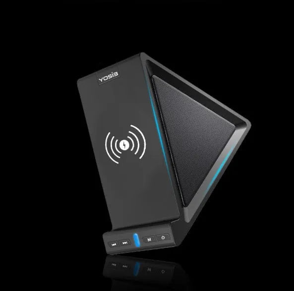 Black ABS Bluetooth speaker with integrated wireless charging pad and phone stand, shown on a desk.