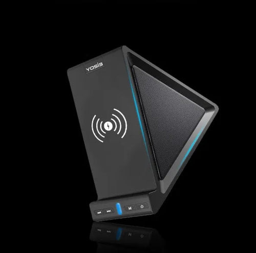 Black ABS Bluetooth speaker with integrated wireless charging pad and phone stand, shown on a desk.