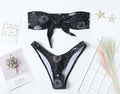 Black bikini print one-piece swimsuit with a split tube top and backless design for women.