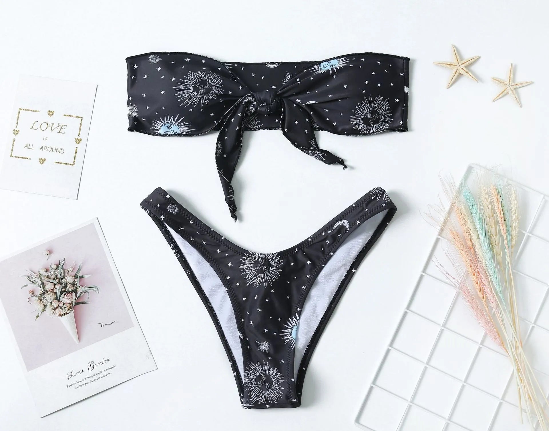 Black bikini print one-piece swimsuit with a split tube top and backless design for women.