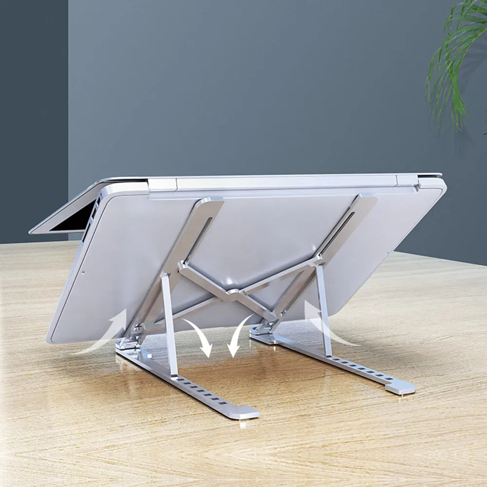 Aluminium laptop stand in silver colour, folded flat next to an open laptop for size comparison.