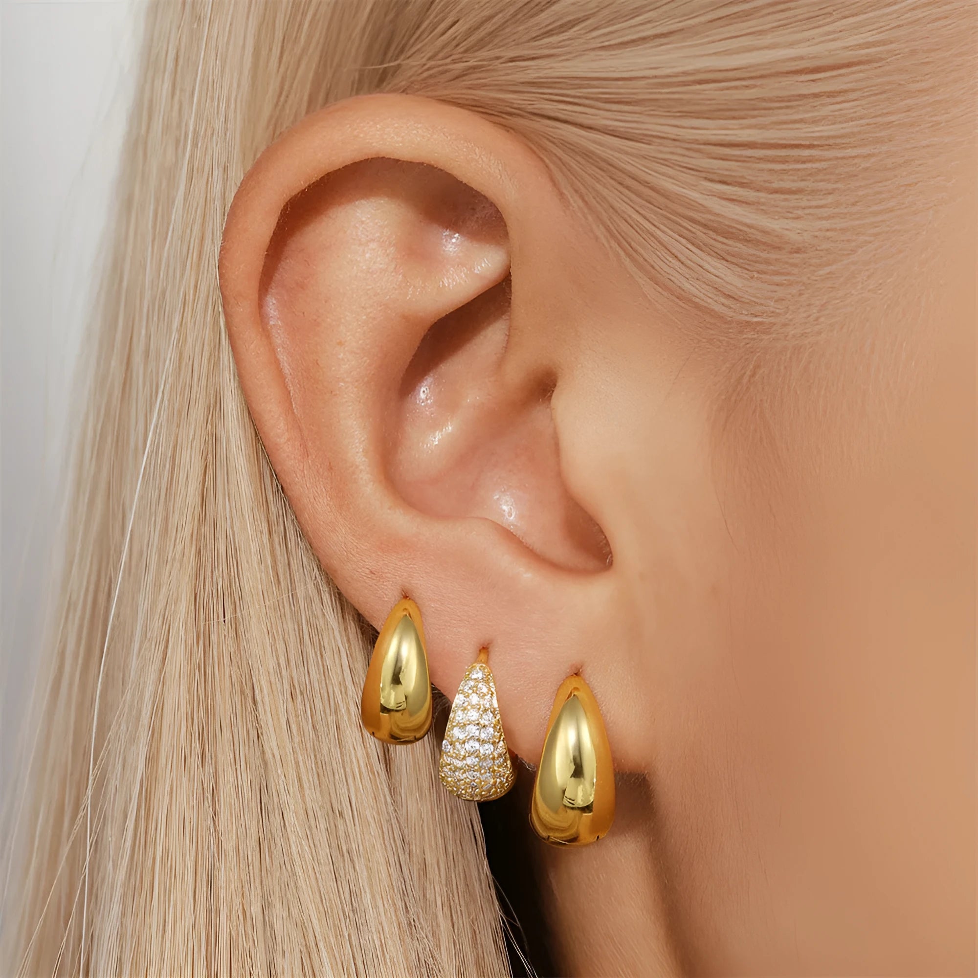 Golden brass earclip earrings with geometric round drop design on white background