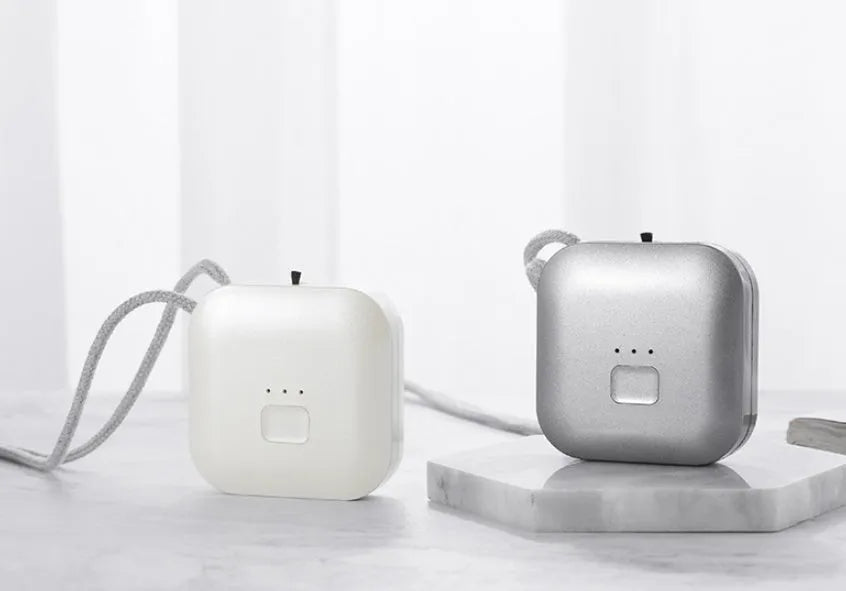 Mini USB portable air purifier necklace in pink, showing compact design with a wearable collar.