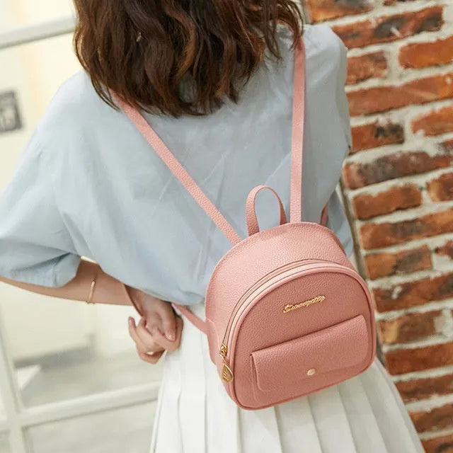 Women's black PU backpack purse with letter design and shoulder strap showing compact 18.5cm length