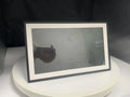 White smart digital photo frame with 15.6 inch screen on a table, showing a family photo.
