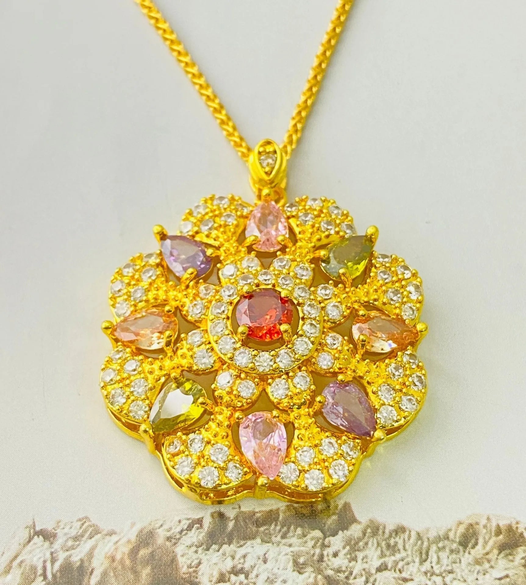 Close-up of a women's flower-shaped zircon pendant necklace in a gold electroplated finish on a model.