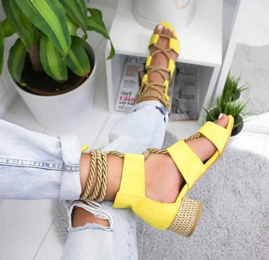 Women's beige suede sandals with thick mid-heel, front strap, and ankle strap on a plain background.