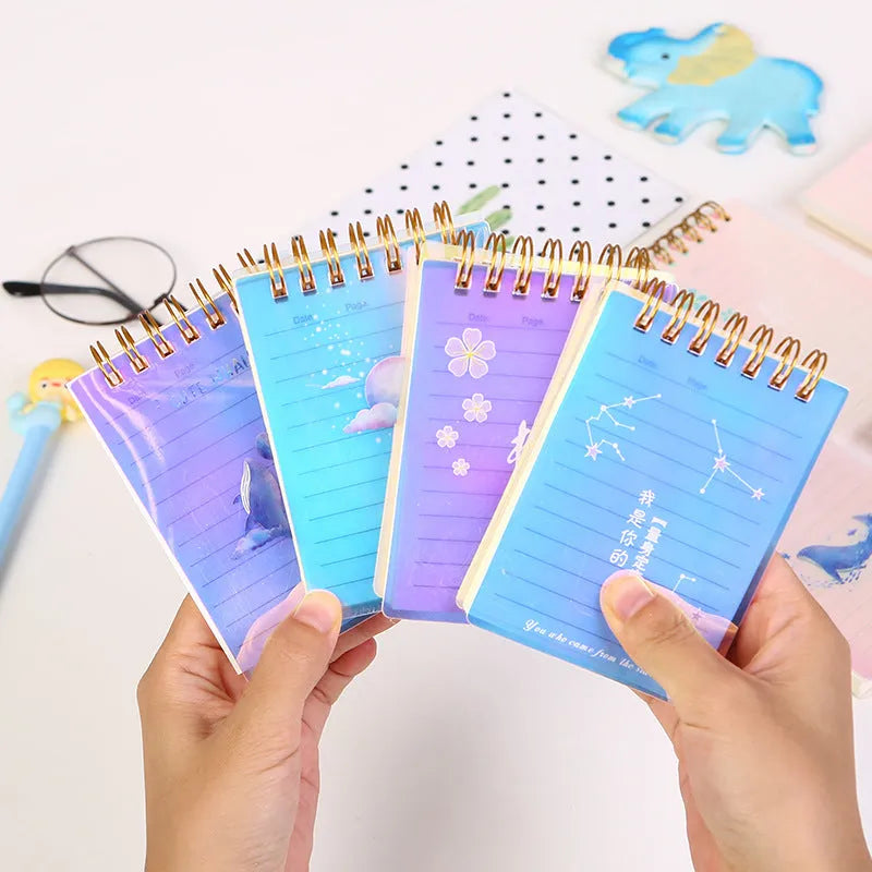 Pack of four rollover coil A7 pocket notebooks showing constellation, sakura, ocean, and universe cover designs