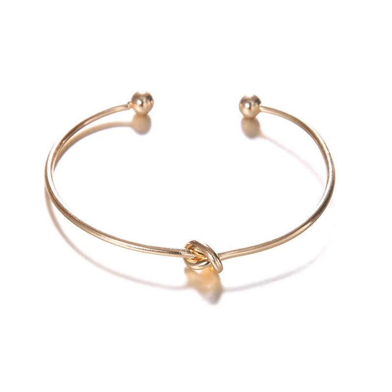 Women's vintage cuff bracelet with arrow knot design in gold electroplated alloy