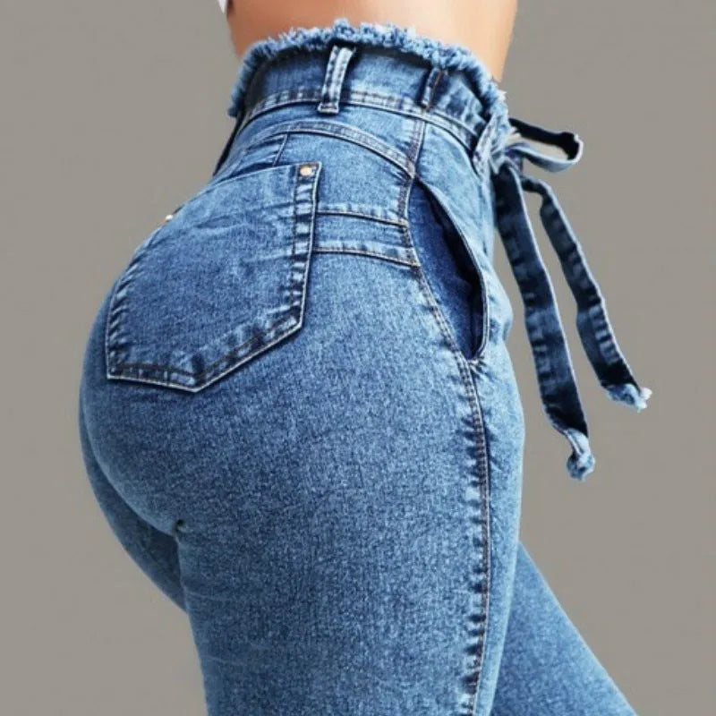 Women's fringed jeans in dark blue denim with frayed hem detailing, size chart displayed