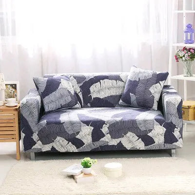 Geometric abstract printed stretch sofa slipcover covering a three-seater sofa with matching cushion covers.