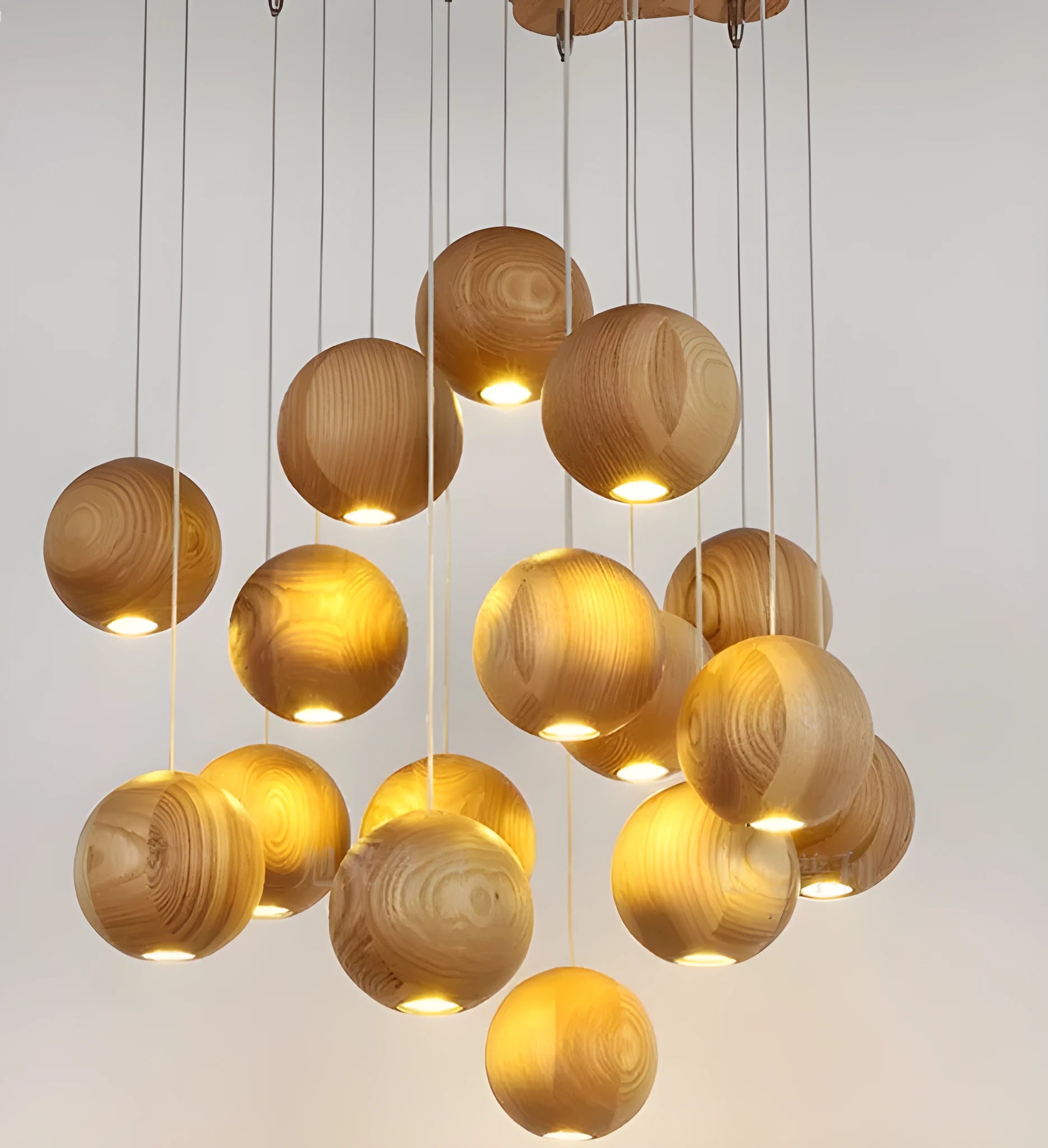 Nordic solid wood ball chandelier hanging lamp with adjustable cord over a dining table.