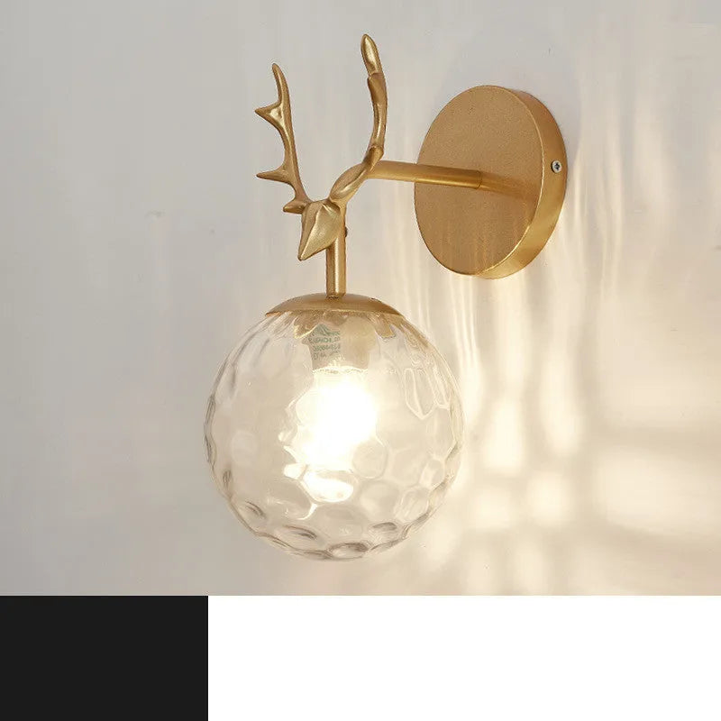 Nordic minimalist round glass wall lamp in golden finish mounted on a wall.