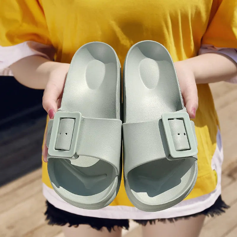 Women's grey blue buckle slippers with a flip-flop design and soft EVA sole on a white background