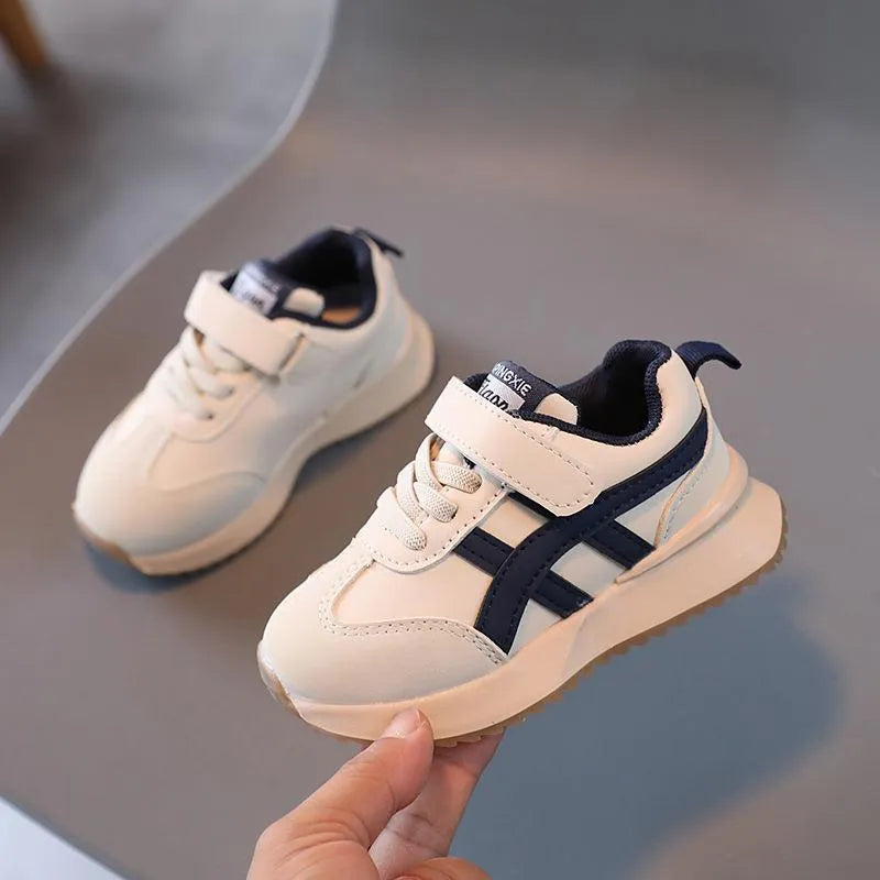 Children's white casual sneaker with Velcro strap on a non-slip rubber sole.