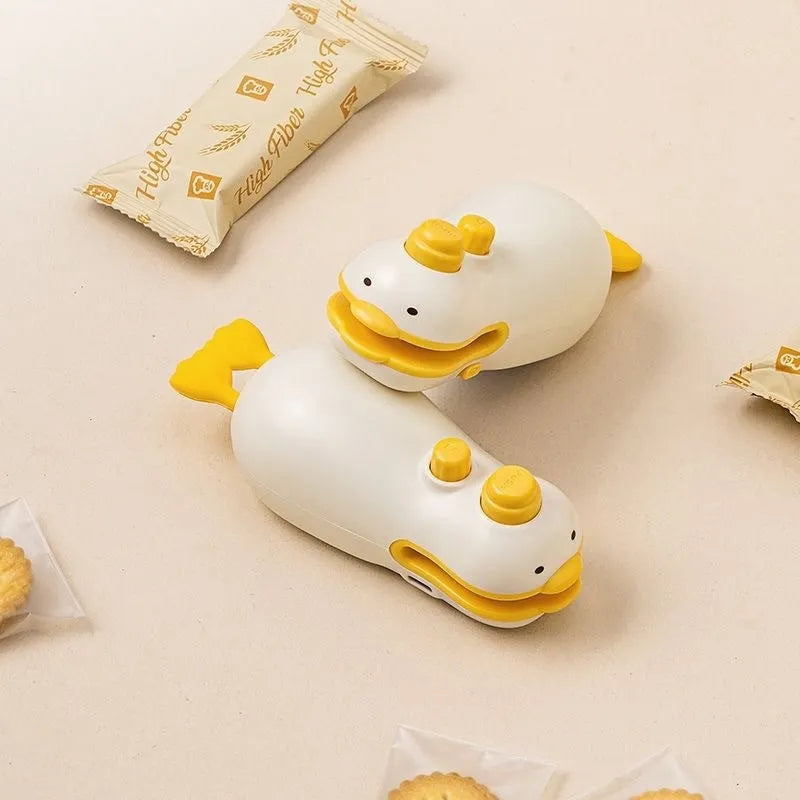 Small yellow duck animal jacquard design rechargeable handheld sealing machine with USB charging cable.