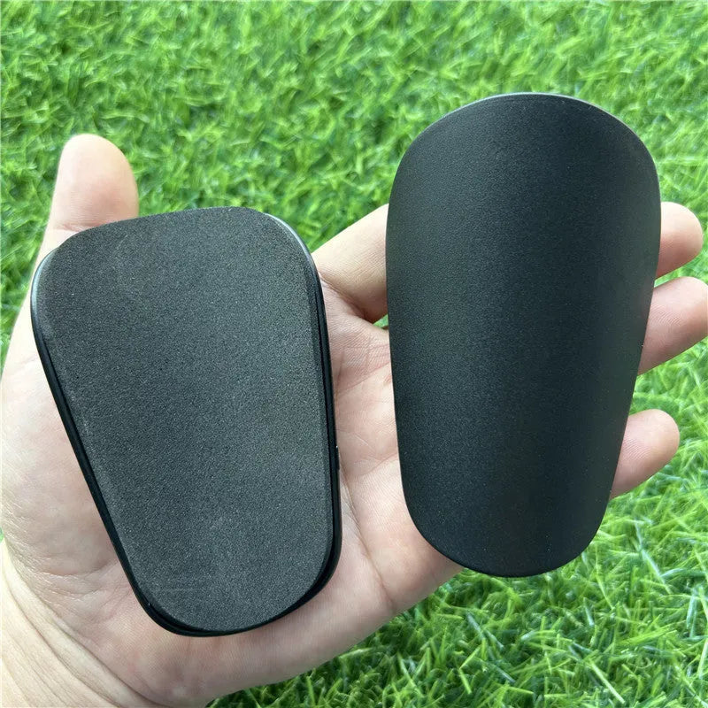 Extra small mini football shin guards in black and white plastic construction