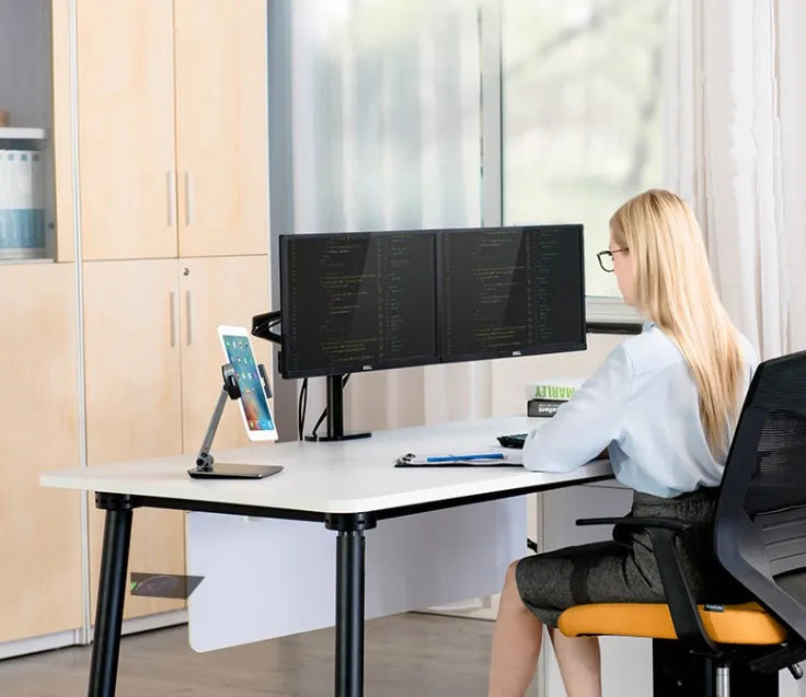 Silver foldable aluminium stand holding a tablet at an angle on a desk