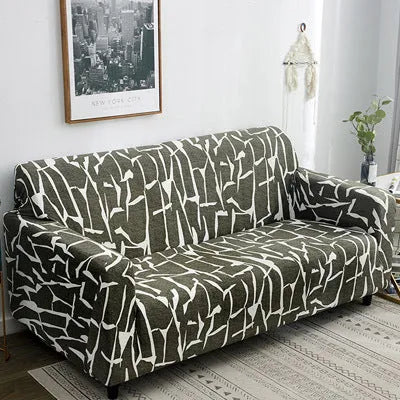 Geometric abstract printed stretch sofa slipcover covering a three-seater sofa with matching cushion covers.