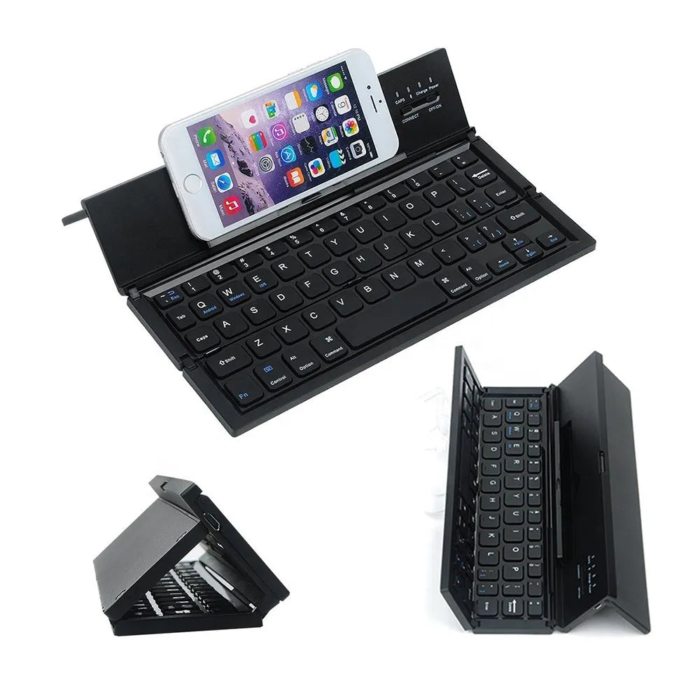 A black mini folding wireless Bluetooth keyboard shown open next to a tablet.