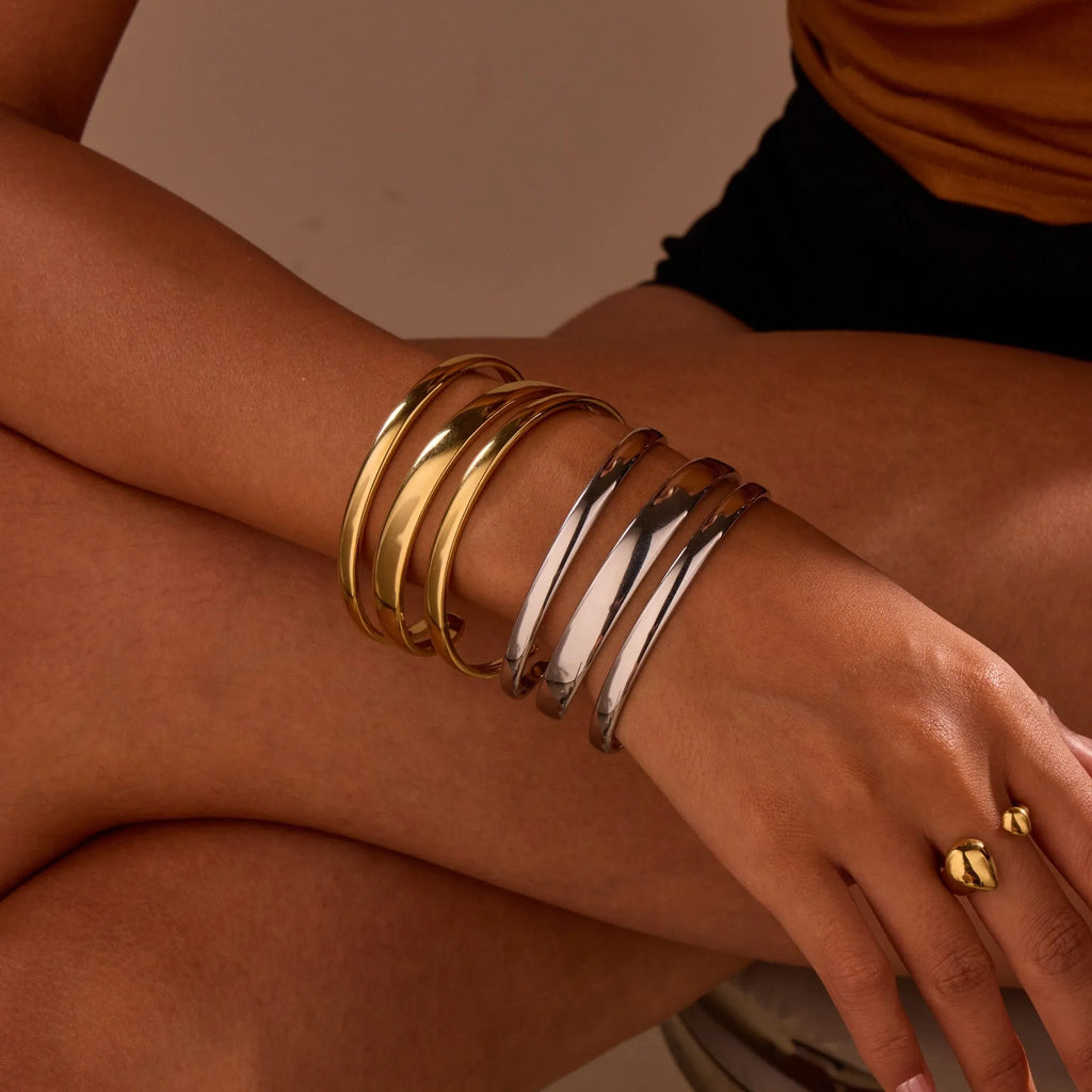 Geometric line design stainless steel women's bracelet with a simple opening clasp, shown in gold and steel colour options.