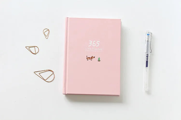 Hardback colour inside notebook planner with 228 pages, open to daily schedule, shown in Dark Green