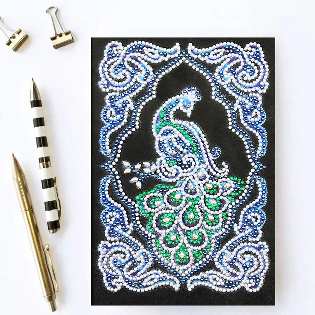 Black hardcover A5 diamond painting notebook with peacock beauty design, showing dimensions 142mm by 207mm.