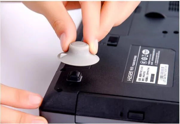 Set of four grey plastic laptop cooling pads: two large and two small, on a desk.