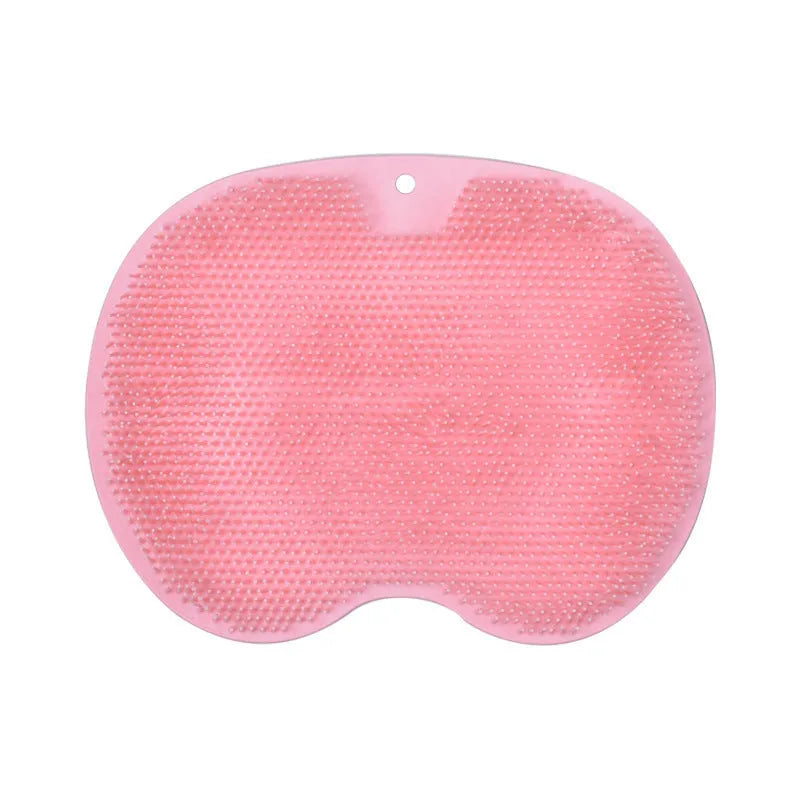 Orange suction cup bath brush with silicone bristles for foot and back cleaning on a bathroom floor.