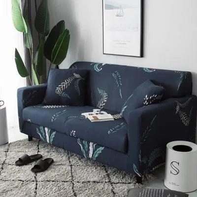 Geometric abstract printed stretch sofa slipcover covering a three-seater sofa with matching cushion covers.
