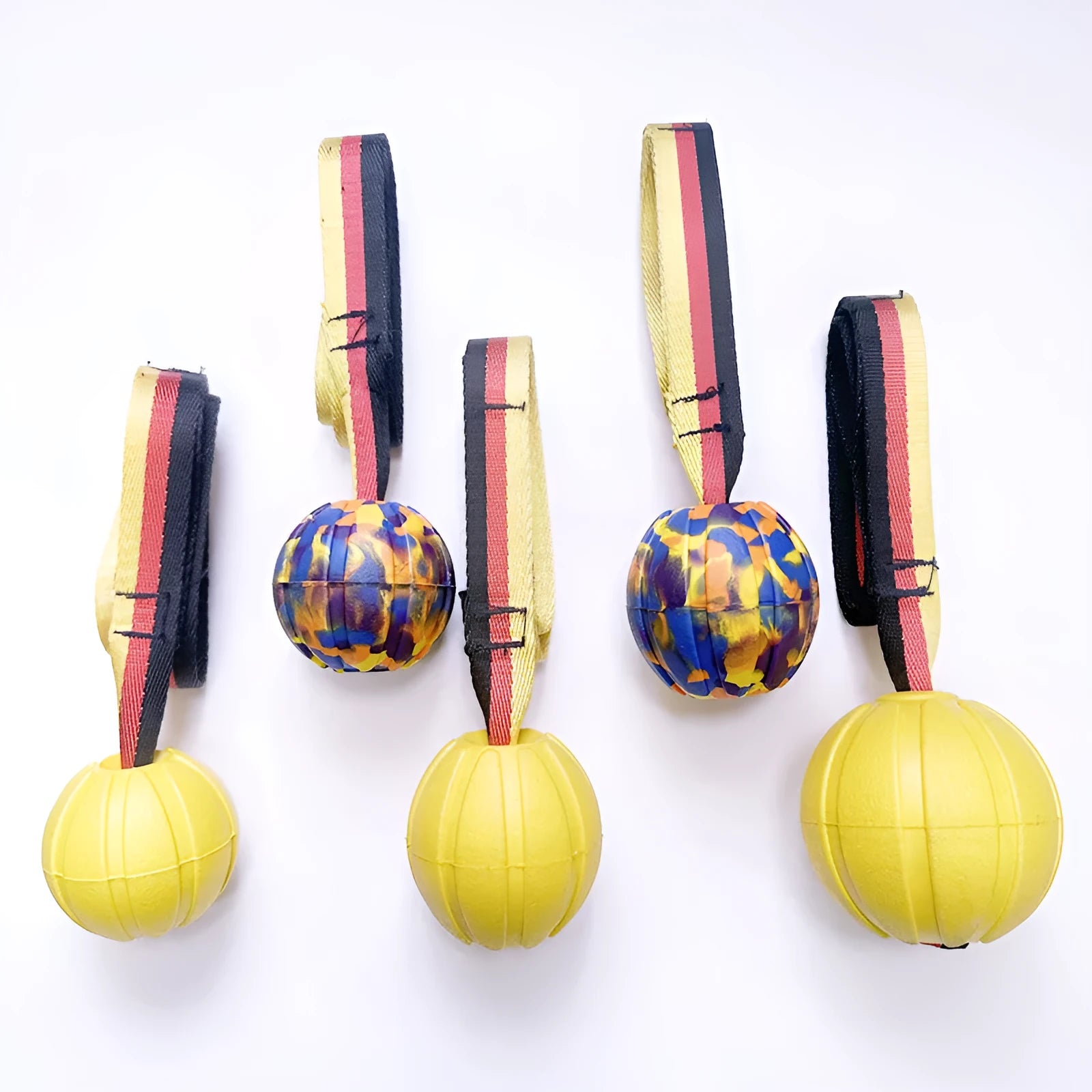 Yellow and camouflage floating EVA foam dog balls with tether strings in three different sizes on a blue background.