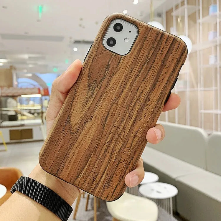 Natural wood grain iPhone back cover case in rosewood finish next to an iPhone