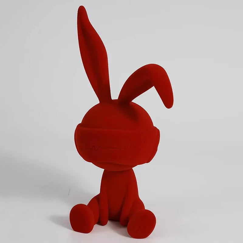 Small resin rabbit table ornament with a suede blindfold, shown in green, blue, and red colour options.