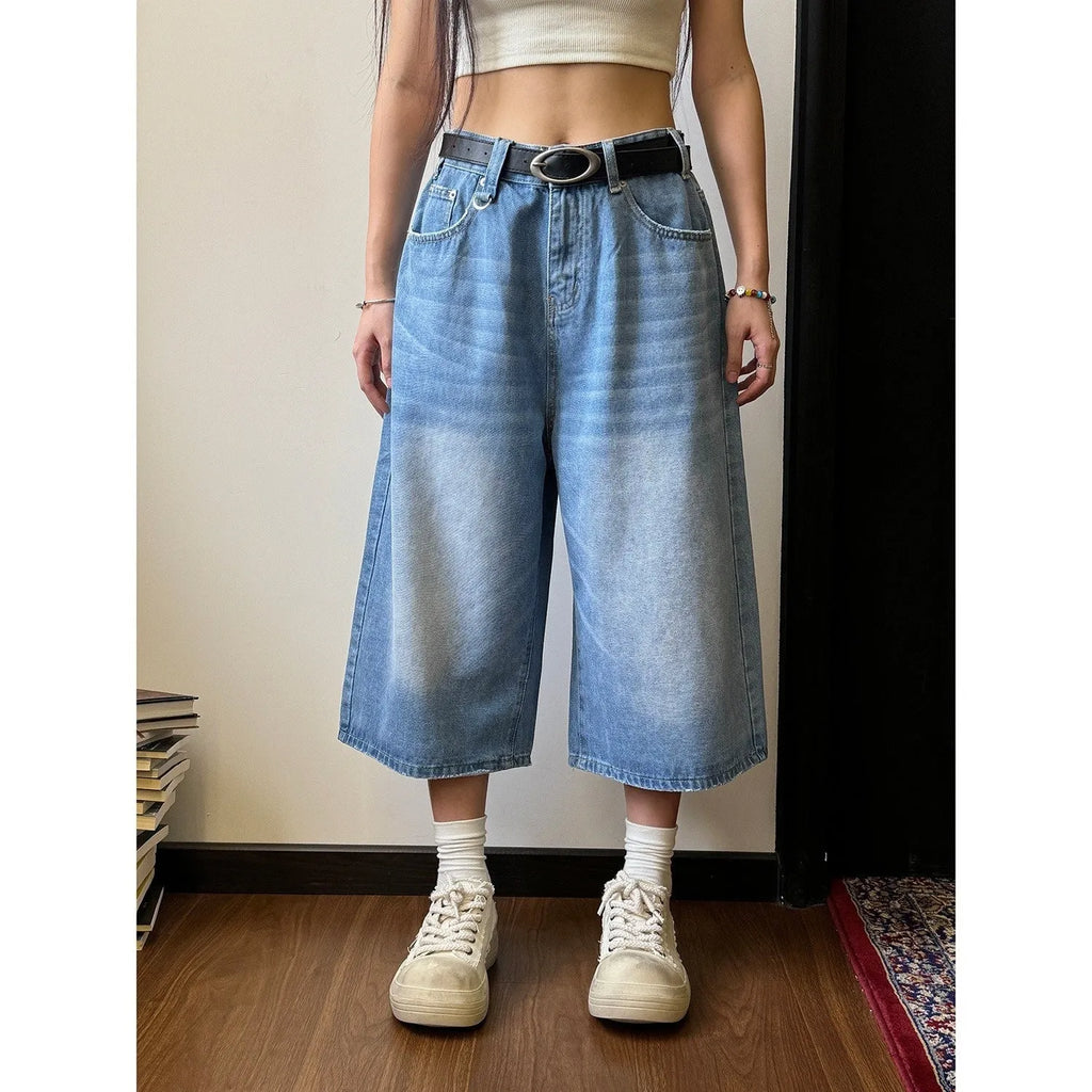 Man wearing blue loose straight-leg denim shorts with a simple summer style.