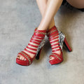 Women's black snakeskin-effect fish mouth high-top shoes with a thick Roman block heel on a white background.