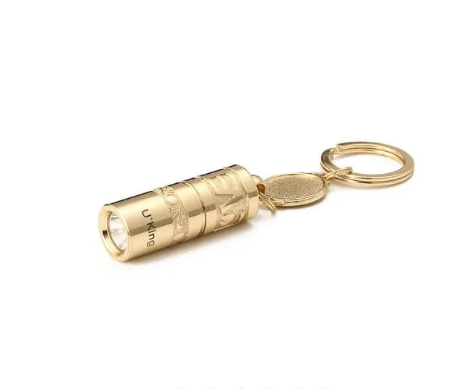 Gold-coloured zinc alloy waterproof mini LED flashlight on a keychain.